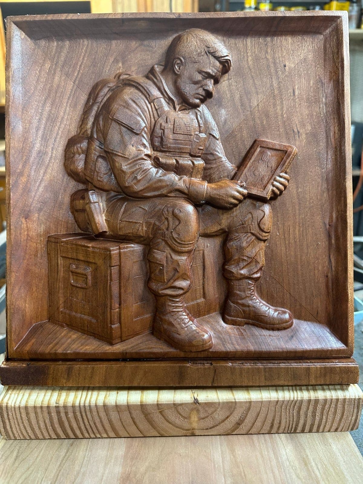 Soldier sitting on locker box looking at a picture of his family